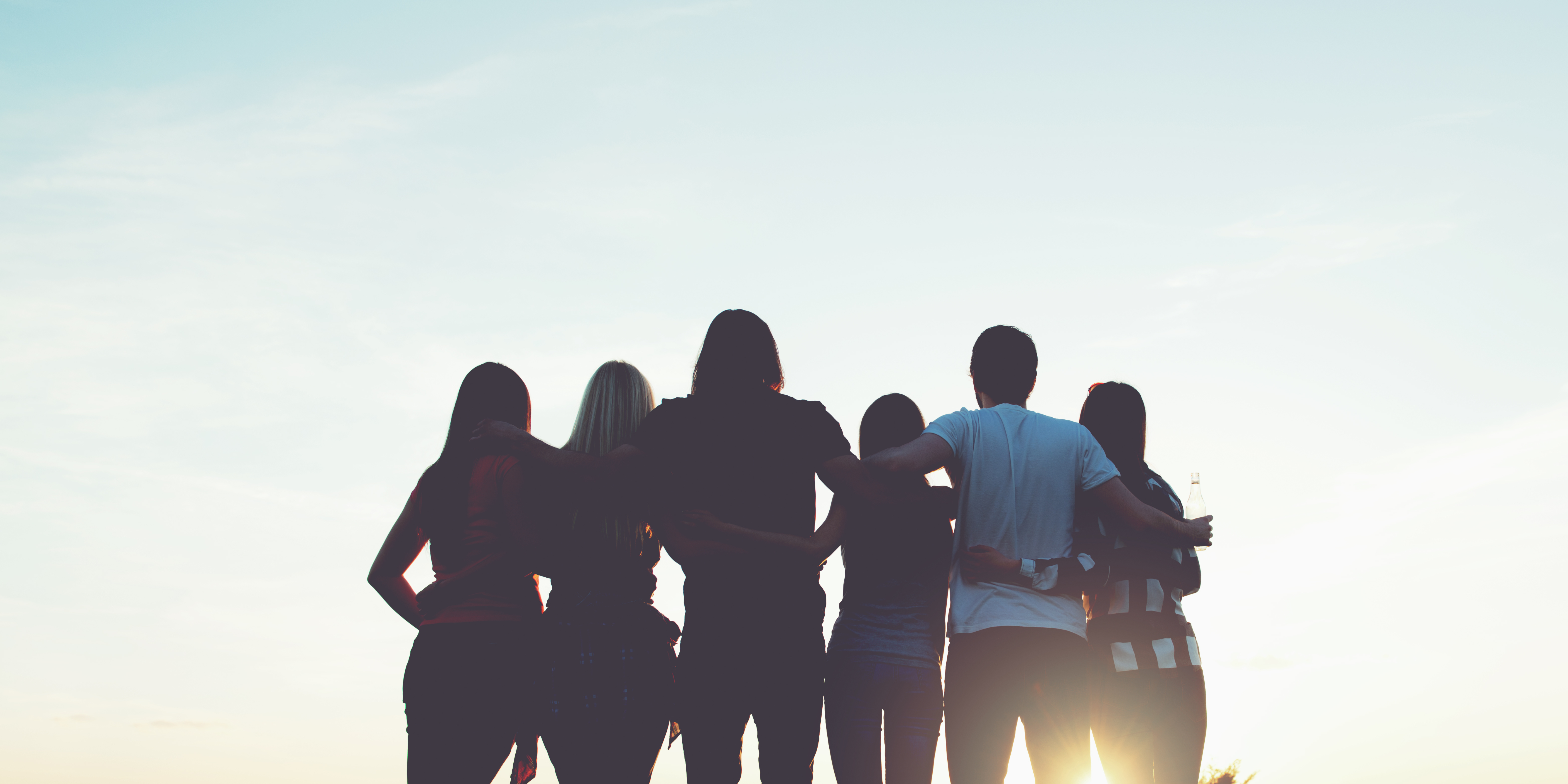 people sitting on chair in front of table while holding pens during daytime
